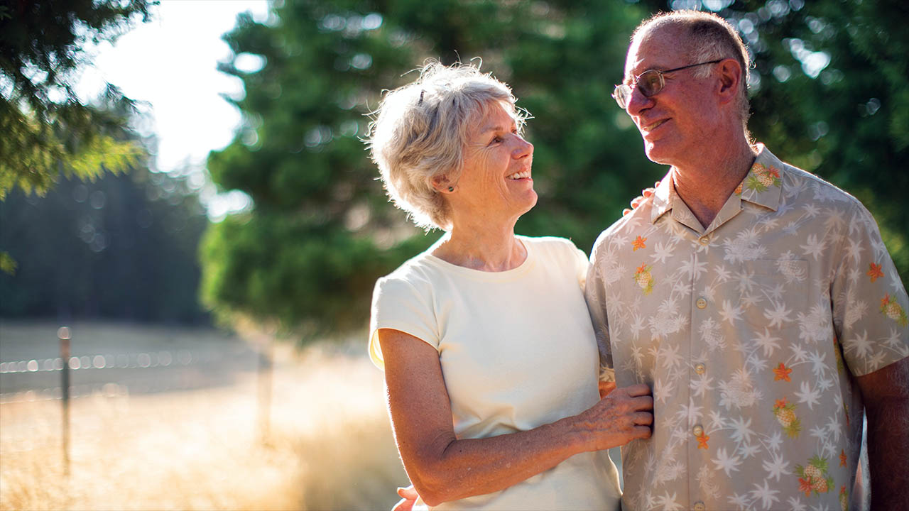 elderly female and male couple smiling at each other